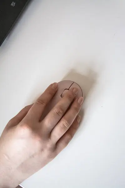 Beyaz arka planda beyaz bir fareyle el ele tutuşan kadın.