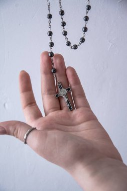 Kadın eli parmaklarıyla haç tutuyor. Yaklaş.