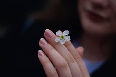 onun elinde bir çiçek tutan güzel bir kadın