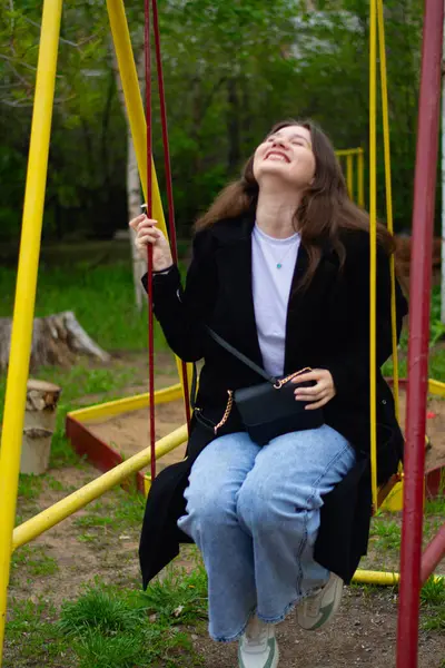 Güzel bir kadın salıncakta oturuyor