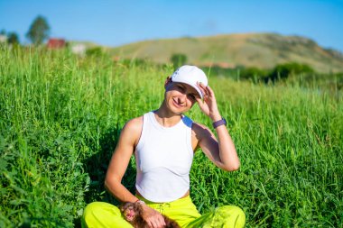 Çimlerin üzerinde oturan bir kadın. Yaz mesleği konsepti. Yüksek kalite fotoğraf.