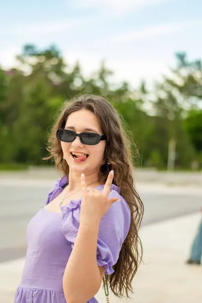 Baş parmak işareti gösteren bir kadının portresi.