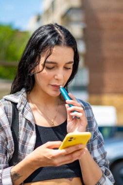 Akıllı telefon kullanan genç bir kadın.