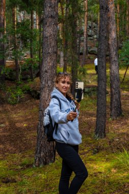 Sonbahar ormanında kameralı bir kadın.