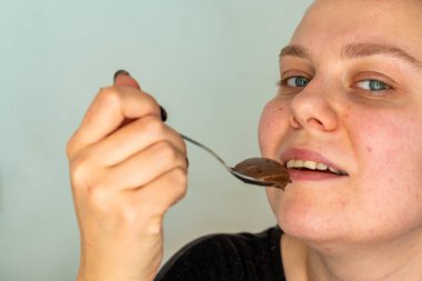 Bir kadın çikolatalı kek yer.