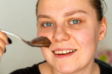 Bir kadın kaşıkla dondurma yer.