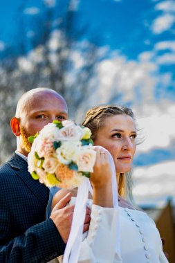 Gelin ve damat çiçek tutuyorlar. Mutlu çift düğün gününde