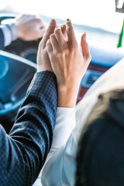 İş adamlarının el ele tutuşup direksiyon başında el ele tutuşmalarının kestiği görüntüler.