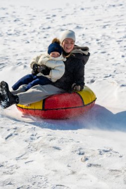 Mutlu baba ve oğul karda eğleniyor.