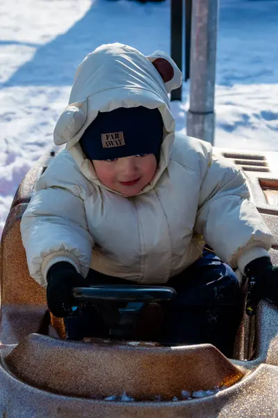 Çocuk karda oynuyor.