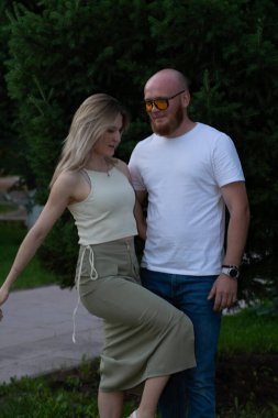 Mutlu genç çift parkta yürüyor ve gülüyor..