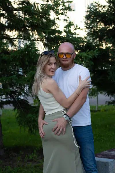 Genç bir çift şehirde parkta yürüyor..