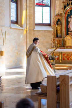 Katolik rahipler, kilise cemaatini Paskalya nöbetinde kutsal suyla kutsar. Yüksek kalite fotoğraf. Yüksek kalite fotoğraf