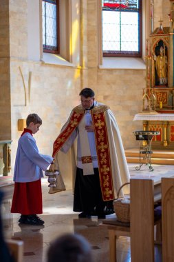 Katolik rahipler, kilise cemaatini Paskalya nöbetinde kutsal suyla kutsar. Yüksek kalite fotoğraf. Yüksek kalite fotoğraf