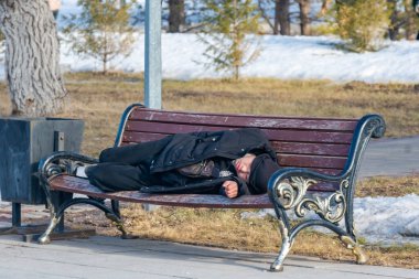 Karaganda, Kazakistan - 3.22.2025: Evsiz kişi kürsüde. Evsiz salgını. yüksek kaliteli fotoğraf. Yüksek kalite fotoğraf