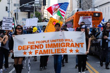Muhtelif protestoculardan oluşan geniş bir kalabalık Los Angeles şehir merkezinde anti-ICE ve Trump karşıtı levhalarla Meksika ve Amerikan bayrakları sallayarak toplanıyor. Siyasi gösteri, göçmen hakları, sosyal adalet ve toplumsal dayanışmayı destekliyor. Fotoğraflı dur