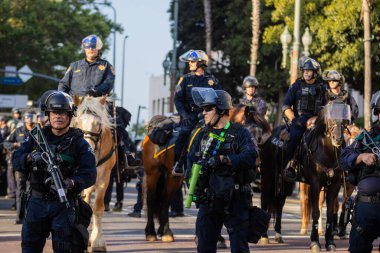 Muhtelif protestoculardan oluşan geniş bir kalabalık Los Angeles şehir merkezinde anti-ICE ve Trump karşıtı levhalarla Meksika ve Amerikan bayrakları sallayarak toplanıyor. Siyasi gösteri, göçmen hakları, sosyal adalet ve toplumsal dayanışmayı destekliyor. Fotoğraflı dur