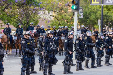Muhtelif protestoculardan oluşan geniş bir kalabalık Los Angeles şehir merkezinde anti-ICE ve Trump karşıtı levhalarla Meksika ve Amerikan bayrakları sallayarak toplanıyor. Siyasi gösteri, göçmen hakları, sosyal adalet ve toplumsal dayanışmayı destekliyor. Fotoğraflı dur