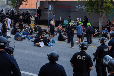Muhtelif protestoculardan oluşan geniş bir kalabalık Los Angeles şehir merkezinde anti-ICE ve Trump karşıtı levhalarla Meksika ve Amerikan bayrakları sallayarak toplanıyor. Siyasi gösteri, göçmen hakları, sosyal adalet ve toplumsal dayanışmayı destekliyor. Fotoğraflı dur