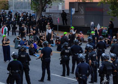 Muhtelif protestoculardan oluşan geniş bir kalabalık Los Angeles şehir merkezinde anti-ICE ve Trump karşıtı levhalarla Meksika ve Amerikan bayrakları sallayarak toplanıyor. Siyasi gösteri, göçmen hakları, sosyal adalet ve toplumsal dayanışmayı destekliyor. Fotoğraflı dur