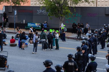 Muhtelif protestoculardan oluşan geniş bir kalabalık Los Angeles şehir merkezinde anti-ICE ve Trump karşıtı levhalarla Meksika ve Amerikan bayrakları sallayarak toplanıyor. Siyasi gösteri, göçmen hakları, sosyal adalet ve toplumsal dayanışmayı destekliyor. Fotoğraflı dur