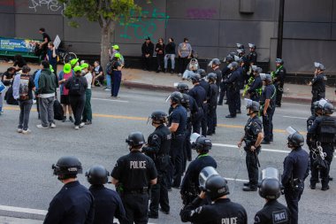 Muhtelif protestoculardan oluşan geniş bir kalabalık Los Angeles şehir merkezinde anti-ICE ve Trump karşıtı levhalarla Meksika ve Amerikan bayrakları sallayarak toplanıyor. Siyasi gösteri, göçmen hakları, sosyal adalet ve toplumsal dayanışmayı destekliyor. Fotoğraflı dur