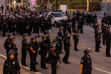 Muhtelif protestoculardan oluşan geniş bir kalabalık Los Angeles şehir merkezinde anti-ICE ve Trump karşıtı levhalarla Meksika ve Amerikan bayrakları sallayarak toplanıyor. Siyasi gösteri, göçmen hakları, sosyal adalet ve toplumsal dayanışmayı destekliyor. Fotoğraflı dur