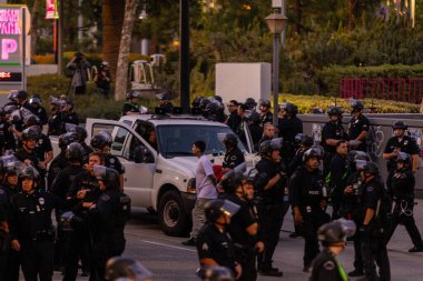 Muhtelif protestoculardan oluşan geniş bir kalabalık Los Angeles şehir merkezinde anti-ICE ve Trump karşıtı levhalarla Meksika ve Amerikan bayrakları sallayarak toplanıyor. Siyasi gösteri, göçmen hakları, sosyal adalet ve toplumsal dayanışmayı destekliyor. Fotoğraflı dur
