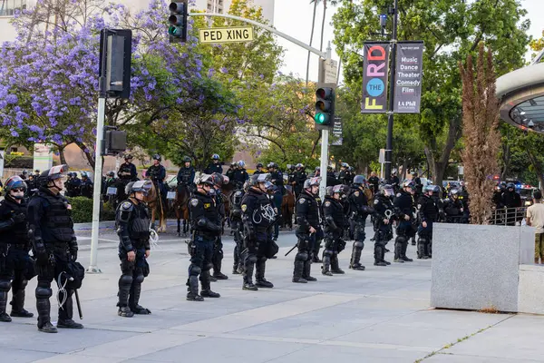 Muhtelif protestoculardan oluşan geniş bir kalabalık Los Angeles şehir merkezinde anti-ICE ve Trump karşıtı levhalarla Meksika ve Amerikan bayrakları sallayarak toplanıyor. Siyasi gösteri, göçmen hakları, sosyal adalet ve toplumsal dayanışmayı destekliyor. Fotoğraflı dur