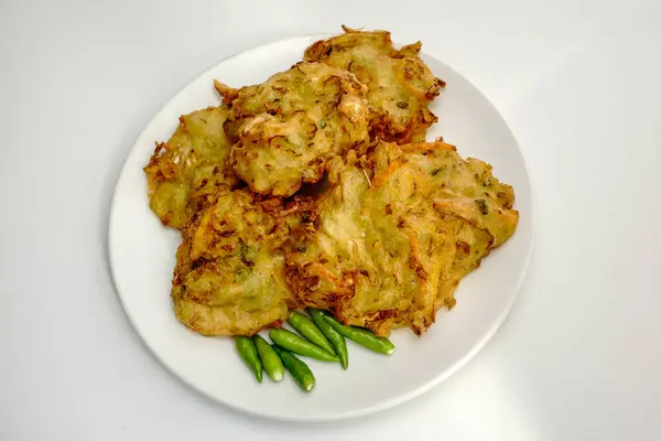 Seçici odak noktası Bakwan Sayur veya Bakwan Goreng veya bala-bala veya ote Endonezya 'dan gelen sebzeli börek, beyaz tabakta kırmızı biber ile servis edilir..