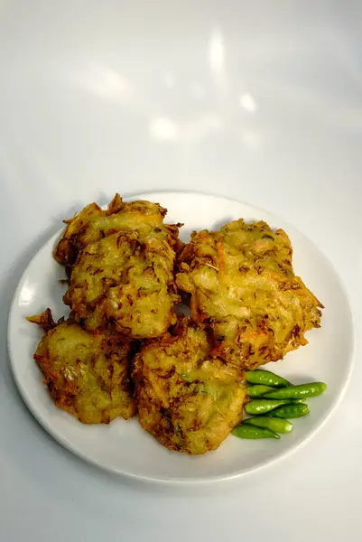 Seçici odak noktası Bakwan Sayur veya Bakwan Goreng veya bala-bala veya ote Endonezya 'dan gelen sebzeli börek, beyaz tabakta kırmızı biber ile servis edilir..