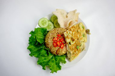 Kızarmış pirinç, tavuk ve sebzeler beyaz tabakta. Nasi Goreng - Endonezya usulü kızarmış tavuklu pilav beyaz tabakta izole edilmiş. Nasi Goreng bir Endonezya mutfağı. Bali yemeği. Asya yemeği. Üst görünüm