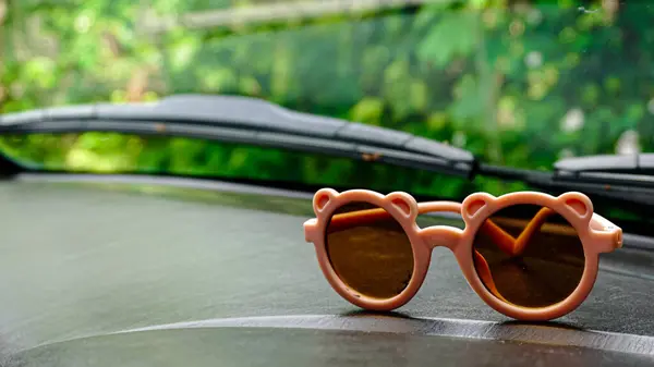 Çocuk güneş gözlükleri arabanın gösterge panelinde