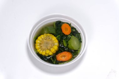 Sayur Bening Bayam, Ispanak Temizleyici Sebze. Ispanaklı Endonezya yemeği, havuçlu ıspanak çorbası, chayote ve mısır. Beyaz arka planda izole edilmiş beyaz kasede servis edilir.