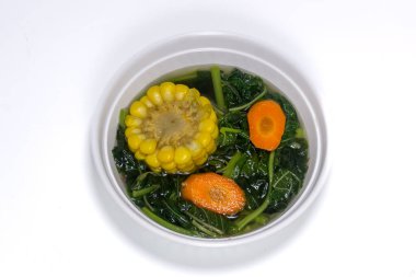 Sayur Bening Bayam, Ispanak Temizleyici Sebze. Endonezya yemeği ıspanak, havuçlu ıspanak çorbası. Beyaz arka planda beyaz kasede servis ediliyor..