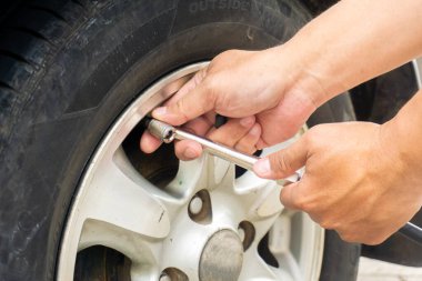 The hands of a man pump air into the wheel of the car with a compressor. Checking and add air pressure . pumping air into auto wheel. vehicle safe concept. clipart