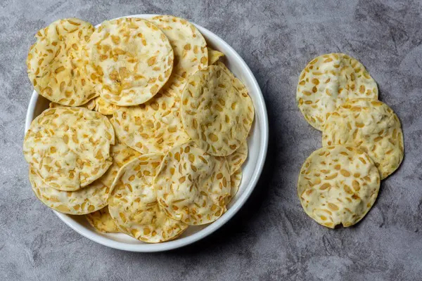 Keripik tempo ya da tempeh cipsleri soya fasulyesinden yapılır ve beyaz tabakta servis edilir. Üst görünüm