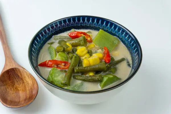 Sayur lodeh ya da Hindistan cevizi sütüyle pişirilmiş sebze çorbası, Endonezya 'nın geleneksel yemeklerinden lezzetli. Chayote, uzun fasulye ve mısırdan oluşur. Kasede servis ediliyor, en iyi manzara. Kapat..