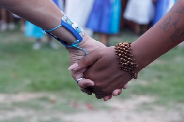 Women from Maracatu, a Brazilian cultural and religious artistic activity, holding hands in a gesture of peace, celebration, respect and friendship clipart