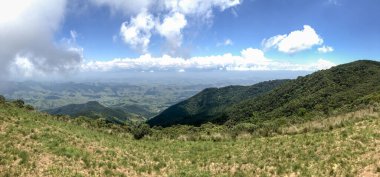 Güneşli bir günde güzel bir dağ manzarası ve güzel bulutlarla yeşilimsi dağlar.