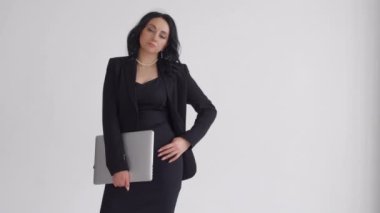Güzel bir kız elinde bir dizüstü bilgisayar tutuyor. Laptoplu bir kızın portresi. Bir iş kadınının portresi. Beyaz arka planda bir kız.