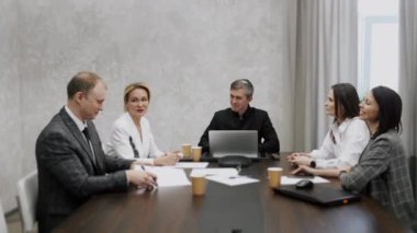 Yönetici takım çalışanları yönetim kurulu toplantısında CEO 'nun proje sonuçlarını tartışmasını dinliyorlar. Çok kültürlü profesyonel şirket liderleri yönetim kurulu masasında çalışıyor..