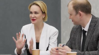 Ofisteki iş toplantısında kadın takım lideri yöneticilerle konuşuyor, strateji planlıyor. Bütünlük kavramı