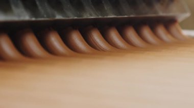 Bir fabrikada otomatik çikolata üretimi. Çikolata kütlesi, dilimlemek için konveyör şeridi boyunca hareket eder..
