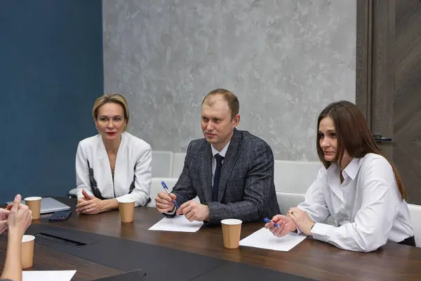 Business meeting in modern office, successful managers discussing project, sharing ideas. Colleagues working together, planning strategy. Concept of business