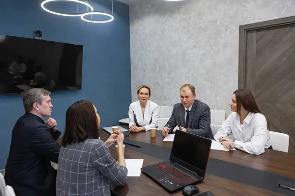 Yönetici takım çalışanları yönetim kurulu toplantısında CEO 'nun proje sonuçlarını tartışmasını dinliyorlar. Çok kültürlü profesyonel şirket liderleri yönetim kurulu masasında çalışıyor..