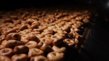 İtalyan taralli yapma süreci. Paketlemeden önce bitmiş ürünleri taşıyan taşıyıcı. Bitmiş taralli fırından çıkıyor. Atıştırma fabrikası. Modern şekerleme fabrikası.