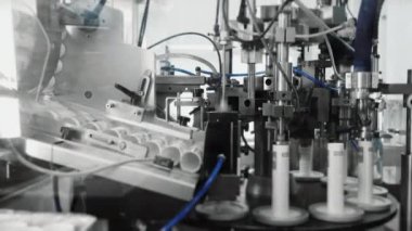 Fabrikada kozmetik ürünleri üretiliyor. El ve vücut kremi üretimi için taşıyıcı. Otomatik olarak kremalı plastik tüpler. Kremalı modern taşıyıcı. 