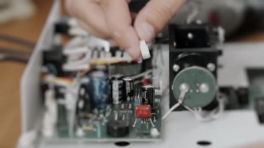 Bir mühendis ya da teknisyen bir bilgisayar panosuna kablo bağlar. Bir mühendis cihazı elle monte eder. Teknik becerileri ve elektronik bakımını göster.