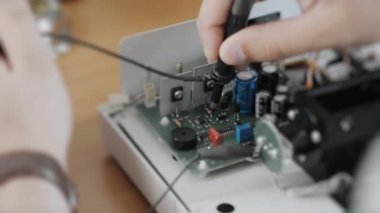 Bir mühendis ya da teknisyen arıza için hatalı bir cihazı test eder. Mühendis özel bir cihazla mikro devreyi kontrol eder. Teknik becerileri ve elektronik bakımını göster.